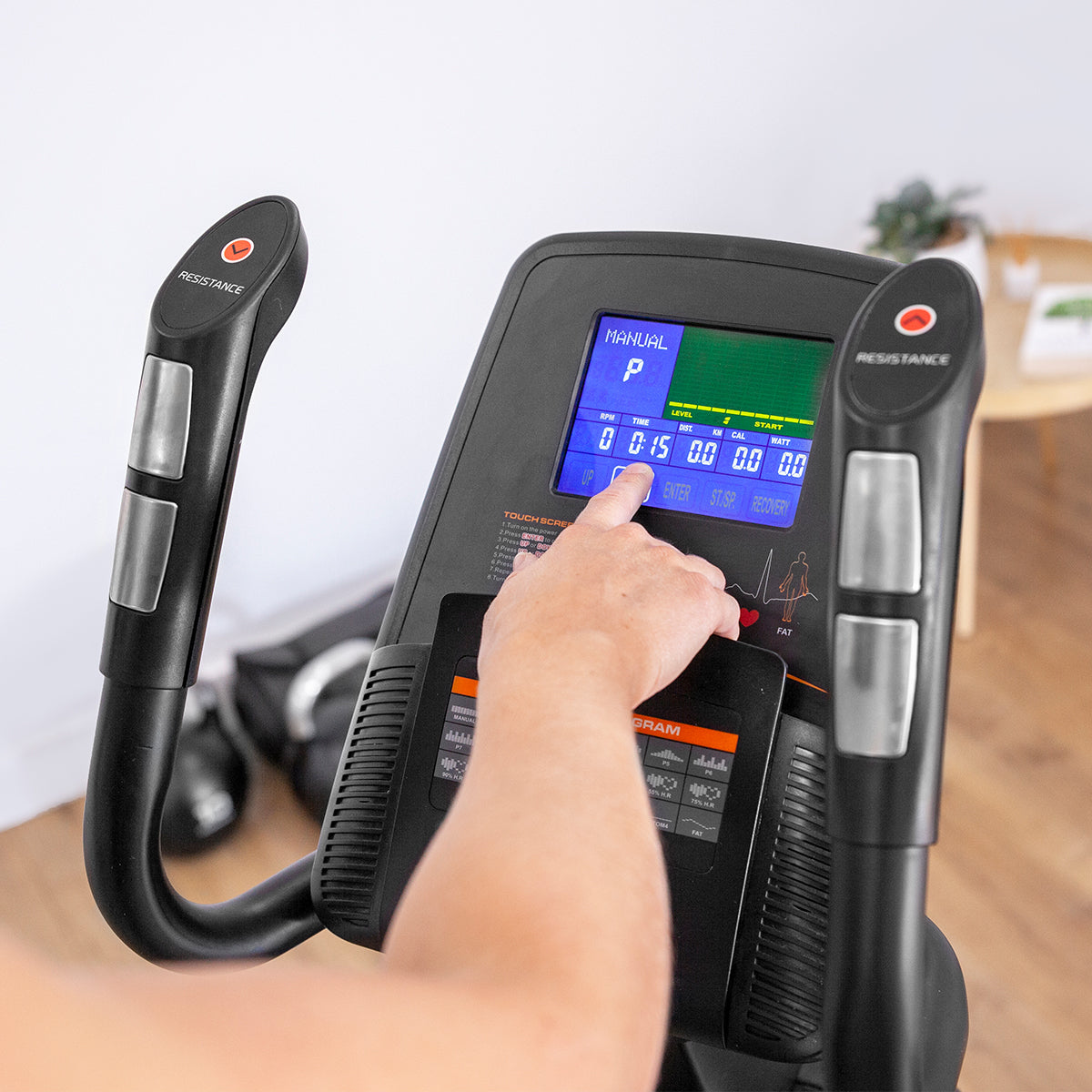 Person adjusting settings on Lifespan Fitness XT-40 Cross Trainer's digital display panel for resistance control.