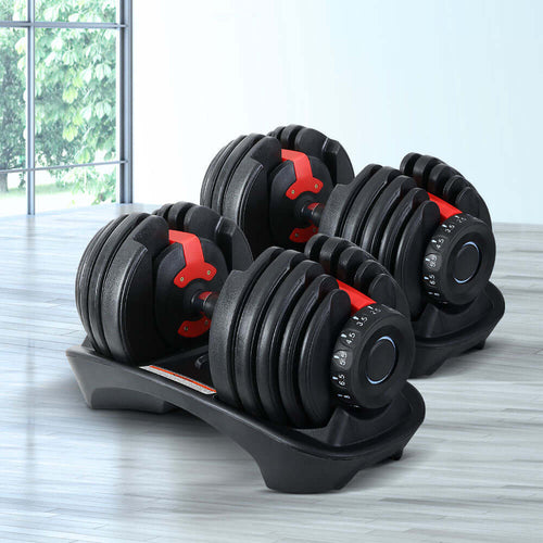 Adjustable Dumbbells 24kg set with weight plates and holders on a gym floor.
