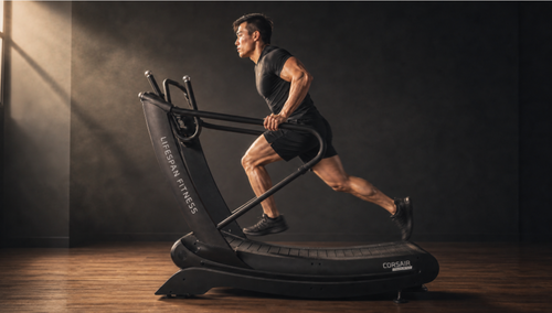 A man running on a black Cosegami LifeSpan Fitness Cheetah-style treadmill in a dark gym setting with dramatic side lighting.