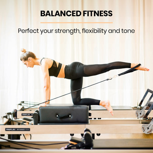 Woman using Pilates Reformer for balanced fitness, improving strength and flexibility on PROFLEX Wooden Folding Stretch Bed.