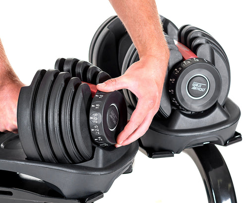 Person adjusting Adjustable Dumbbells with Stand 24KG Set, showcasing the 15 adjustable levels for tailored resistance at home.