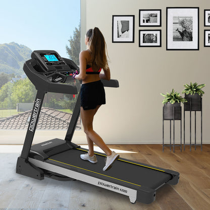 Woman exercising on Powertrain K2000 Treadmill with Auto Incline and Fan in modern home gym setting