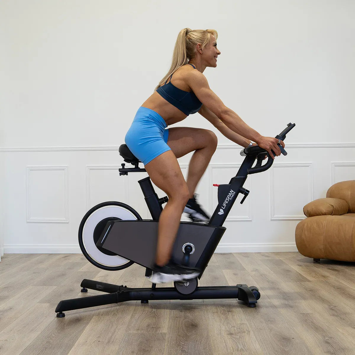 Spin bike with magnetic resistance being used for a workout in a stylish home setting.
