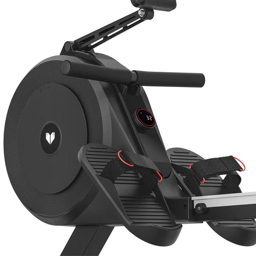 Close-up of a rowing machine with dual air and magnetic resistance, showcasing the footrests and monitor display.