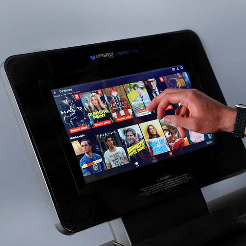 User interacting with the touchscreen display on a Commercial Treadmill – Lifespan Tempest CRX Smart TFT.