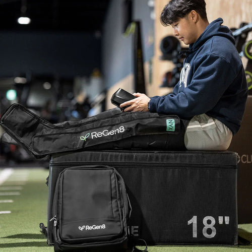 Athlete using ReGen8 Compression Recovery Boots for enhanced recovery and performance in a gym.