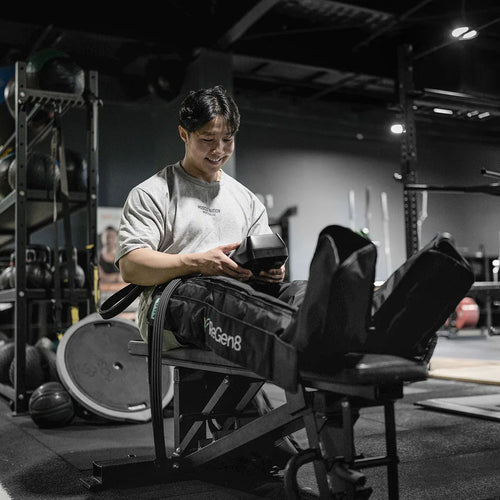 Man using ReGen8 Compression Recovery Boots in gym for effective muscle recovery and relaxation.