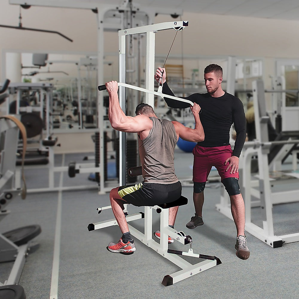 Man using Home Fitness Multi Gym Lat Pull Down Machine with trainer in gym setting, focusing on upper body strength workout.